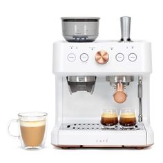 an espresso machine with two glasses next to it