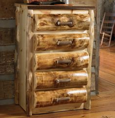 a wooden dresser with drawers and a teddy bear on it's top, sitting in front of a log wall