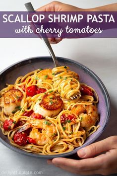 scallop shrimp pasta with cherry tomatoes in a skillet being held by two hands