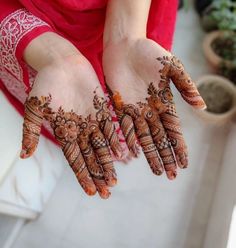 a woman holding her hands with henna on it