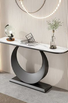 a modern console table with marble top and metal base in front of a striped wall