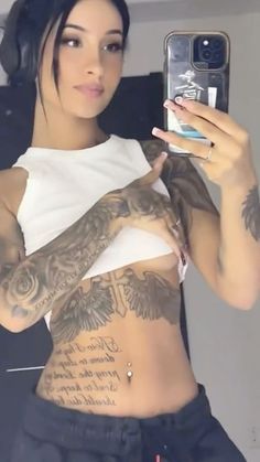 a woman taking a selfie with her cell phone in front of her chest and arm