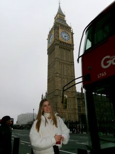 a woman standing in front of the big ben clock tower