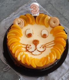 a cake decorated to look like a lion with orange slices on it's face