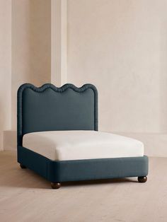 a bed with a blue headboard and foot board on top of wooden flooring