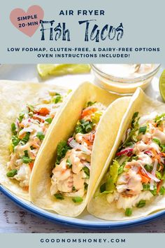 two fish tacos on a plate with lime wedges