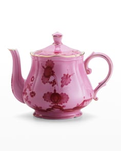 a pink tea pot with flowers painted on it