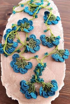 crocheted blue flowers on a piece of wood