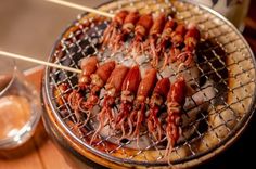 several skewered lobsters are being grilled on a grill with toothpicks