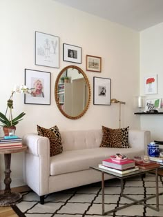 a living room filled with lots of furniture and pictures on the wall above it's coffee table