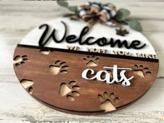 a wooden sign that says welcome to cats