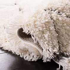 a white rug is laying on top of a wooden floor and it's covering the area