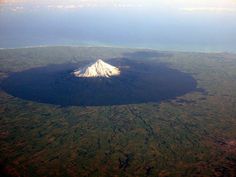 an aerial view of a large crater in the middle of nowhere with snow on top