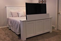 a bed with a white headboard and foot board in a room that has carpet on the floor