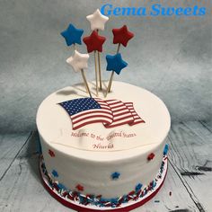 a white cake with red, white and blue stars on top that says genda sweets