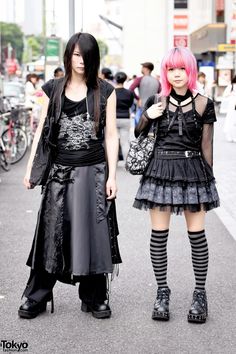 two women with pink hair are walking down the street