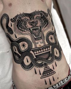 a man with a tattoo on his stomach has an image of a tiger and snake