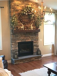 a living room with a fire place and christmas decorations on the fireplace mantels