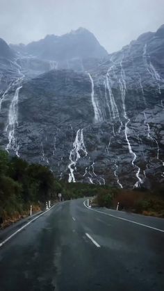 an empty road with mountains in the background