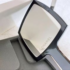 the side view mirror is on top of a gray tray with white sheets behind it