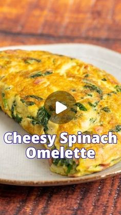 an omelette on a plate with the words cheesy spinach omelette