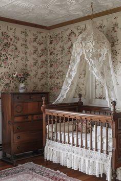 an old fashioned crib in a room with floral wallpaper and white netting over it