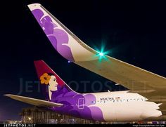 two large passenger jets sitting on top of an airport tarmac at night with the lights on