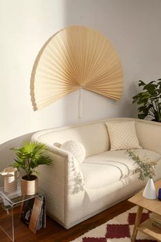 a living room filled with furniture and a large fan above the couch in front of it