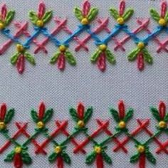 a close up of a piece of cloth with different colored stitches and flowers on it