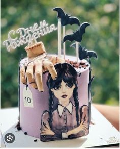 there is a cake decorated to look like a girl with bats on her head and hands