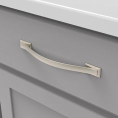 a close up of a drawer handle on a gray cabinet with white drawers in the background