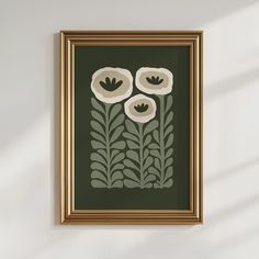 a painting hanging on the wall with white flowers and green leaves in front of it