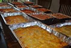 many pans of food are lined up on the table