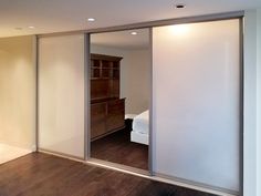 an empty room with sliding glass doors leading to a bed and dresser in the corner