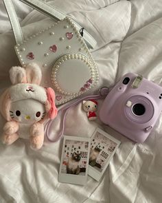 a camera, stuffed animal and other items on a bed