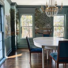 a dining room with blue chairs and a chandelier