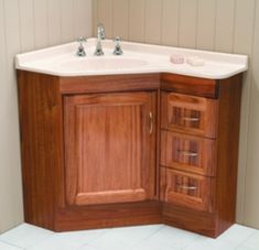 a bathroom sink with wooden cabinets and white tile flooring in front of a wall