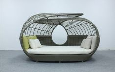 a wicker couch with pillows and a mirror behind it