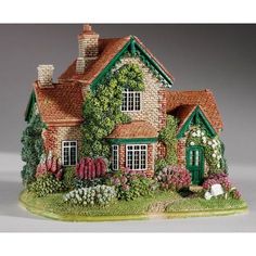 a figurine of a house with flowers and plants