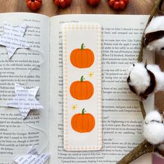 an open book with cotton floss and pumpkins on the page next to it