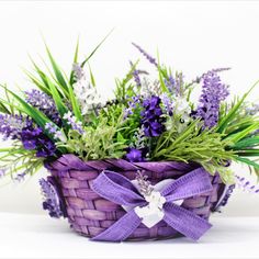 a wicker basket filled with purple flowers and greenery