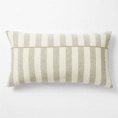 a white and grey striped pillow on a white wall