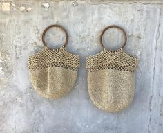 two bags hanging on the side of a wall, one is made out of jute