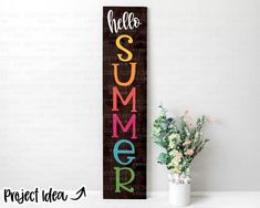 a wooden sign that says hello summer next to a potted plant