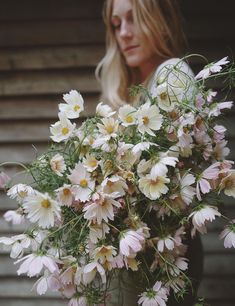 a woman holding a bouquet of white and pink flowers