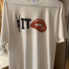 a white t - shirt with the word it on it and a red lipstick print