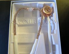 a white and gold necklace in a box