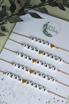 four white and gold toothpicks with the words team braut written on them