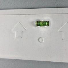 a white electrical outlet with two green arrows on it