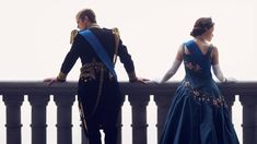 a man and woman dressed in blue standing on a balcony